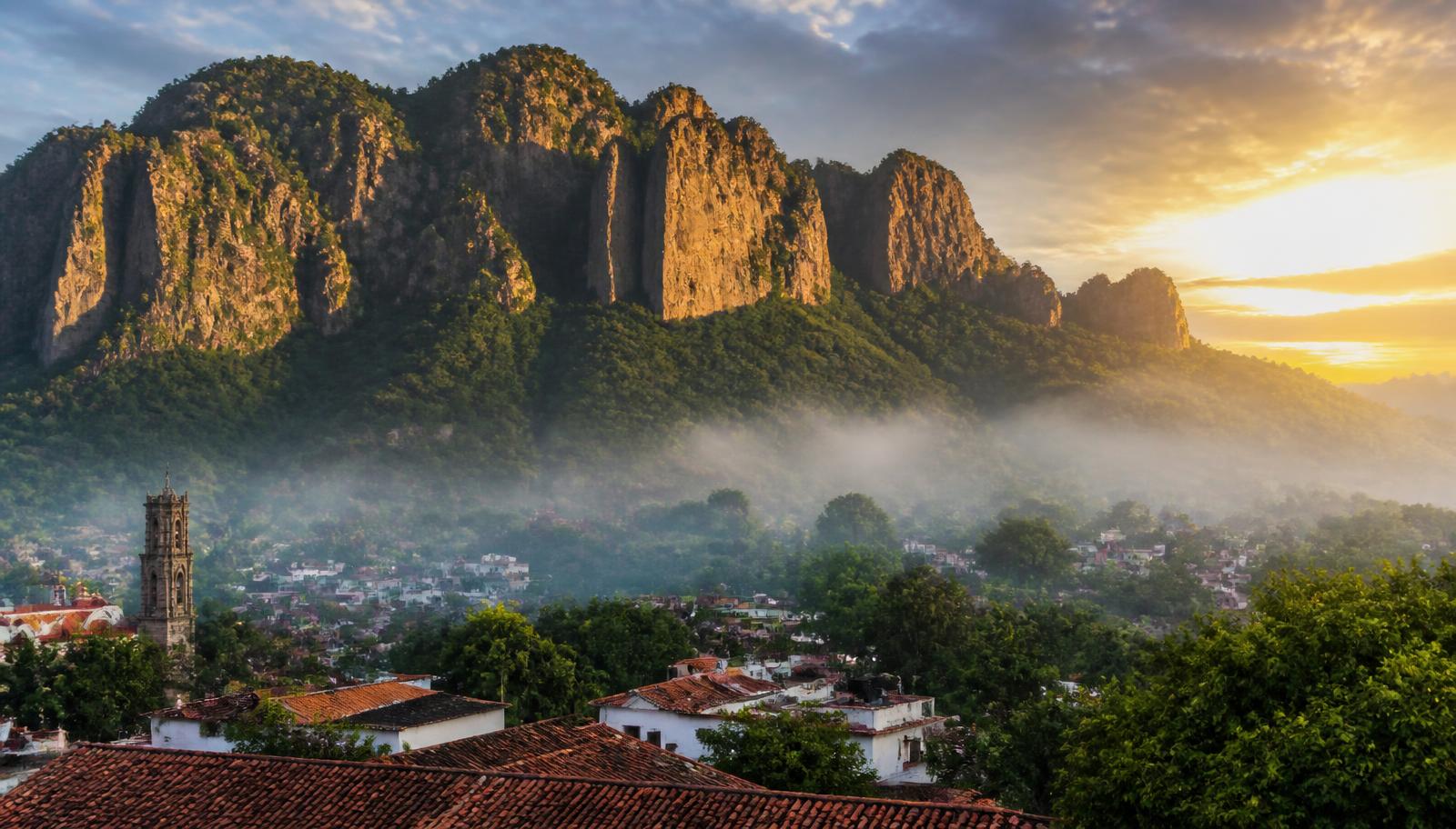 El cerro del Tepozteco al amanecer sobre los techos de teja de Tepoztlán